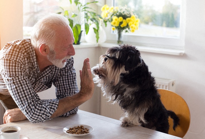 a man sitting at a table with his dog